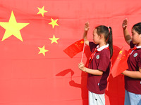 Students of Chuzhou No. 4 Primary School in Chuzhou, China, on September 27, 2024, take a photo with the national flag to welcome National D...