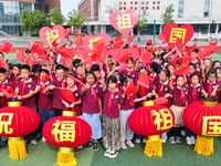 Students of Chuzhou No. 4 Primary School in Chuzhou, China, on September 27, 2024, carry red lanterns printed with the words ''Bless the mot...