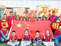 Students of Chuzhou No. 4 Primary School in Chuzhou, China, on September 27, 2024, take a photo with the national flag to welcome National D...