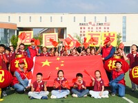 Students of Chuzhou No. 4 Primary School in Chuzhou, China, on September 27, 2024, carry red lanterns printed with the words ''Bless the mot...