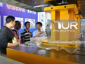 An exhibitor introduces production equipment to foreign customers at the 17th China Handan (Yongnian) Fastener and Equipment Exhibition in H...