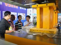 An exhibitor introduces production equipment to foreign customers at the 17th China Handan (Yongnian) Fastener and Equipment Exhibition in H...