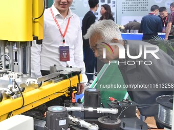 Buyers visit production equipment at the 17th China Handan (Yongnian) Fastener and Equipment Exhibition in Handan, Hebei province, China, on...