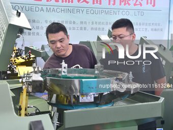 Buyers visit production equipment at the 17th China Handan (Yongnian) Fastener and Equipment Exhibition in Handan, Hebei province, China, on...