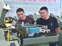 Buyers visit production equipment at the 17th China Handan (Yongnian) Fastener and Equipment Exhibition in Handan, Hebei province, China, on...