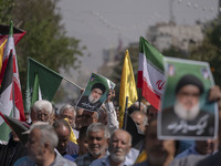 An Iranian worshipper carries a portrait of Lebanon's Hezbollah Secretary General, Hassan Nasrallah, during an anti-Israeli protest to conde...