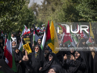 Iranian female worshippers carry flags while taking part in an anti-Israeli protest to condemn Israel's military attack on Lebanon, after Fr...