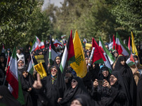 Iranian female worshippers carry flags while taking part in an anti-Israeli protest to condemn Israel's military attack on Lebanon, after Fr...