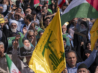 Iranian worshippers carry portraits of Lebanon's Hezbollah Secretary General, Hassan Nasrallah, during an anti-Israeli protest to condemn Is...