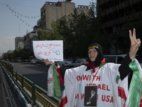 An Iranian female protester, wearing a shroud covered with anti-U.S. and anti-Israeli slogans and a portrait of Iran's Supreme Leader Ayatol...