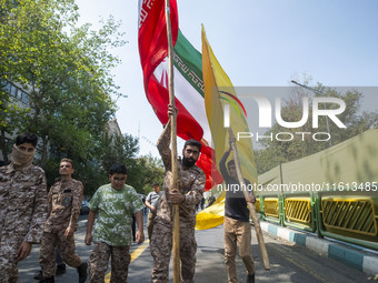 Islamic Revolutionary Guard Corps (IRGC) military personnel carry an Iranian flag and a flag of Lebanon's Hezbollah before an anti-Israeli p...