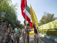 Islamic Revolutionary Guard Corps (IRGC) military personnel carry an Iranian flag and a flag of Lebanon's Hezbollah before an anti-Israeli p...