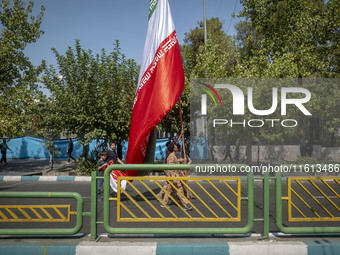 Islamic Revolutionary Guard Corps (IRGC) military personnel carry a giant Iranian flag before an anti-Israeli protest to condemn Israel's mi...