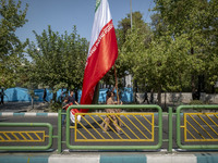 Islamic Revolutionary Guard Corps (IRGC) military personnel carry a giant Iranian flag before an anti-Israeli protest to condemn Israel's mi...