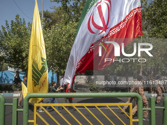 Islamic Revolutionary Guard Corps (IRGC) military personnel and schoolboys carry an Iranian flag and a flag of Lebanon's Hezbollah before an...