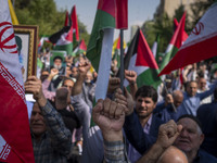 Iranian worshippers shout anti-Israel and anti-U.S. slogans while taking part in an anti-Israeli protest to condemn Israel's military attack...