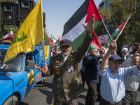 An Iranian worshipper wearing a fake military uniform carries a Lebanon Hezbollah flag while shouting anti-Israeli slogans as he takes part...