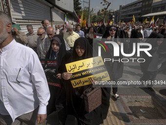 A veiled Iranian worshipper carries an anti-Israeli placard while taking part in an anti-Israeli protest to condemn Israel's military attack...