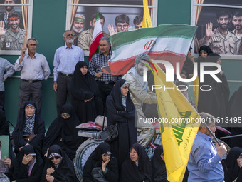 Iranian worshippers stand in front of symbolic portraits of Iranian warriors during an anti-Israeli protest to condemn Israel's military att...