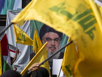 Iranian worshippers wave Lebanon's Hezbollah flags in front of a portrait of the Hezbollah Secretary General, Hassan Nasrallah, during an an...