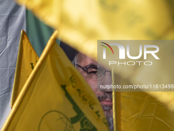 Iranian worshippers wave Lebanon's Hezbollah flags in front of a portrait of the Hezbollah Secretary General, Hassan Nasrallah, during an an...