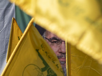 Iranian worshippers wave Lebanon's Hezbollah flags in front of a portrait of the Hezbollah Secretary General, Hassan Nasrallah, during an an...