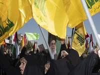 Iranian worshippers wave Lebanon's Hezbollah flags as one of them holds a portrait of Iran's Supreme Leader, Ayatollah Ali Khamenei, while t...