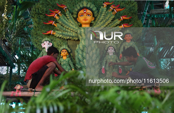 Artisans decorate an idol of the Hindu goddess Durga with eight thousand natural plants to raise awareness about global deforestation, clima...