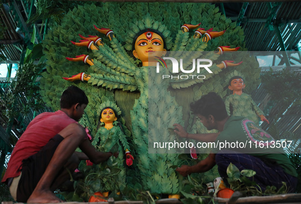 Artisans decorate an idol of the Hindu goddess Durga with eight thousand natural plants to raise awareness about global deforestation, clima...