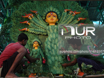 Artisans decorate an idol of the Hindu goddess Durga with eight thousand natural plants to raise awareness about global deforestation, clima...