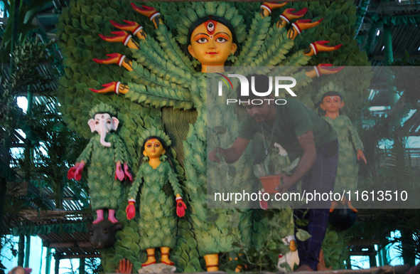 An artisan decorates an idol of the Hindu goddess Durga with eight thousand natural plants to raise awareness about global deforestation, cl...