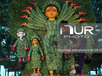 An artisan decorates an idol of the Hindu goddess Durga with eight thousand natural plants to raise awareness about global deforestation, cl...