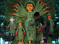 An artisan decorates an idol of the Hindu goddess Durga with eight thousand natural plants to raise awareness about global deforestation, cl...