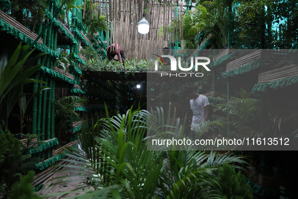 Artisans decorate a pandal with eight thousand natural plants to raise awareness about global deforestation, climate change, the importance...