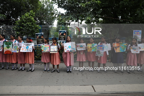 School students form a human chain and hold posters during a Global Climate Strike march in Kolkata, India, on September 27, 2024. 