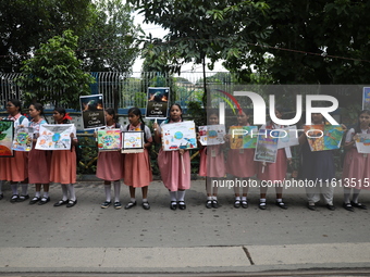 School students form a human chain and hold posters during a Global Climate Strike march in Kolkata, India, on September 27, 2024. (