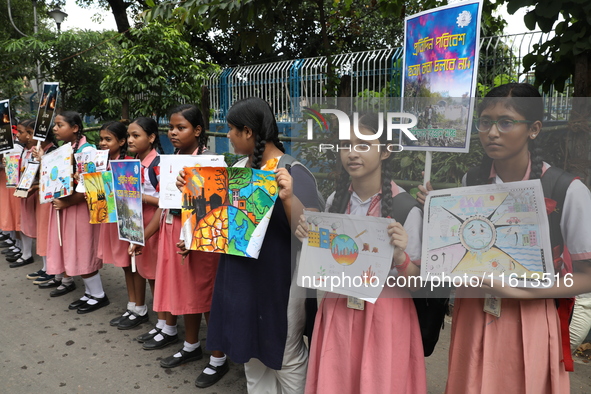 School students form a human chain and hold posters during a Global Climate Strike march in Kolkata, India, on September 27, 2024. 