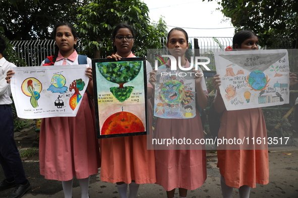 School students form a human chain and hold posters during a Global Climate Strike march in Kolkata, India, on September 27, 2024. 