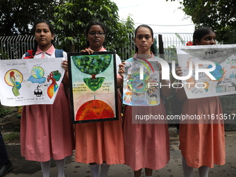 School students form a human chain and hold posters during a Global Climate Strike march in Kolkata, India, on September 27, 2024. (