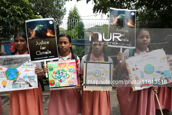 School students form a human chain and hold posters during a Global Climate Strike march in Kolkata, India, on September 27, 2024. 