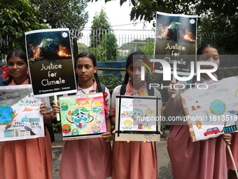 School students form a human chain and hold posters during a Global Climate Strike march in Kolkata, India, on September 27, 2024. (