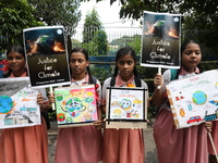 School students form a human chain and hold posters during a Global Climate Strike march in Kolkata, India, on September 27, 2024. (