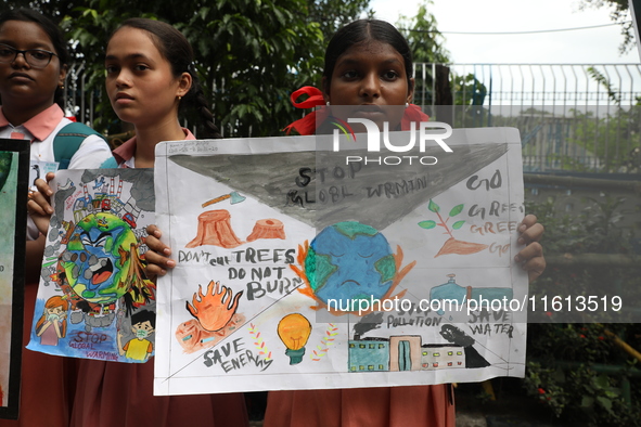 School students form a human chain and hold posters during a Global Climate Strike march in Kolkata, India, on September 27, 2024. 