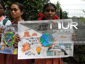 School students form a human chain and hold posters during a Global Climate Strike march in Kolkata, India, on September 27, 2024. (