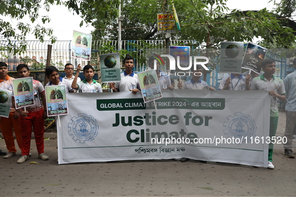 School students form a human chain and hold posters during a Global Climate Strike march in Kolkata, India, on September 27, 2024. 