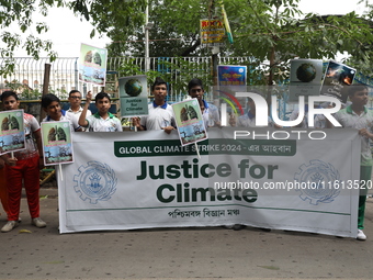 School students form a human chain and hold posters during a Global Climate Strike march in Kolkata, India, on September 27, 2024. (