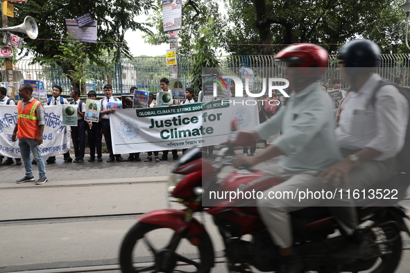 School students form a human chain and hold posters during a Global Climate Strike march in Kolkata, India, on September 27, 2024. 