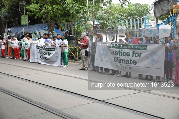 School students form a human chain and hold posters during a Global Climate Strike march in Kolkata, India, on September 27, 2024. 