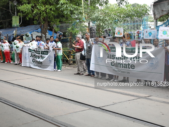 School students form a human chain and hold posters during a Global Climate Strike march in Kolkata, India, on September 27, 2024. (