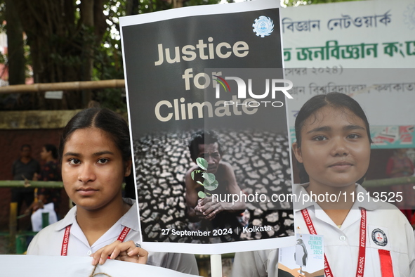 School students form a human chain and hold a poster during a Global Climate Strike march in Kolkata, India, on September 27, 2024. 